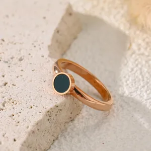 Primo piano di anello minimalista in acciaio al titanio oro rosa con intarsio nero