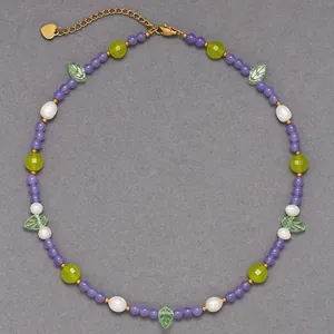 Vue détaillée d'un collier de perles coloré fait main avec perles et breloques feuilles.