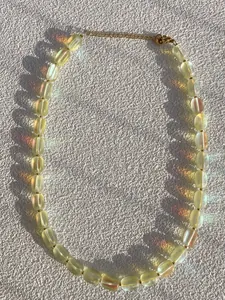Gros plan détaillé montrant les perles de verre irisées sur ce collier fait main