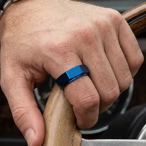 Detaillierte Makroansicht von einem blauen gebürsteten Edelstahlring am Finger