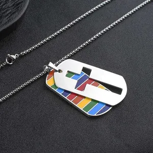 Macro detail of stainless steel dog tag necklace featuring cross and rainbow stripes.
