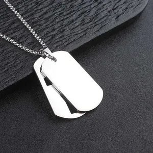 Detail shot of a polished silver stainless steel double dog tag pendant on a black surface