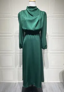 Elegante abito lungo in raso verde smeraldo a maniche lunghe su un manichino