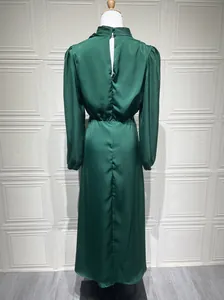 Dettaglio della vista posteriore di un elegante abito lungo in raso verde scuro con apertura