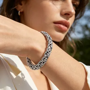 Detailansicht eines silbernen Byzantiner-Kettenarmbands am Handgelenk im Licht