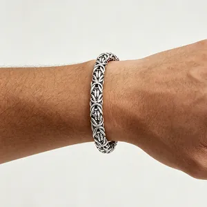 Nahaufnahme eines Herrenarmbands aus Titanstahl mit Byzantinerkette am Handgelenk.