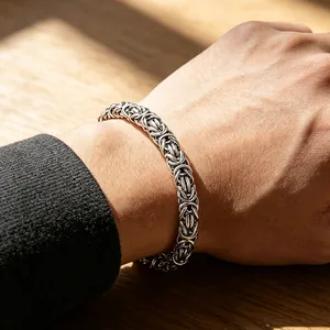 Nahaufnahme eines handgewebten Herren-Byzantiner-Armbands aus Titanstahl am Gelenk.