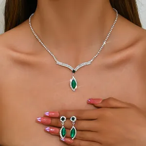 Elegant jewelry set featuring marquise emerald green gems and sparkling crystals on model