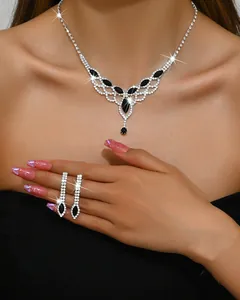 Elegant silver-tone necklace and drop earrings set with black crystals on a model