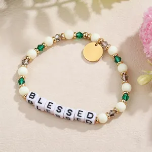 Detailansicht eines handgefertigten Armbandes mit grünen Kristallen und BLESSED-Perlen