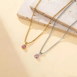 Detail of gold and silver stainless steel necklaces with round pink zircon pendants