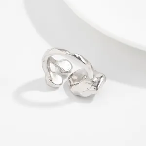 Gros plan d'une bague irrégulière en métal fondu argenté avec texture organique