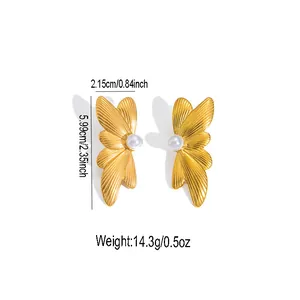 Detailed macro view showing golden wing-shaped stud earrings with white pearl centers
