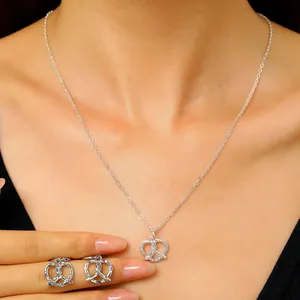 Vista dettagliata del set collana e orecchini a forma di pretzel in argento con zirconi