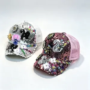 Detalle de dos gorras de lentejuelas con parches de cisne y elegantes acentos florales