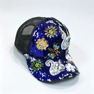 Detalle de gorra de béisbol de lentejuelas azules con cisne de strass y decoraciones