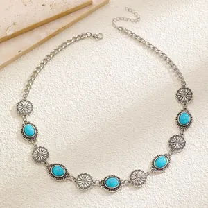 Detailed macro view of a vintage-style turquoise necklace with floral silver-tone links.