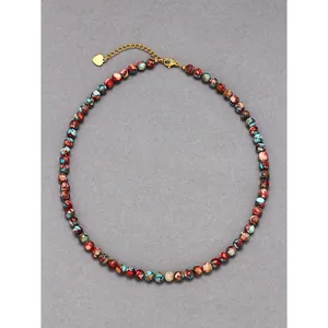 Detail view of bohemian colorful natural stone beaded necklace with gold heart charm