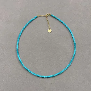 Detailed view of bohemian turquoise beaded necklace with golden heart charm pendant
