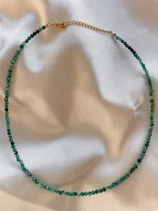 Detail showing faceted green natural stone beads on a gold-plated adjustable choker necklace