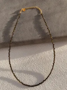 Detail of thin faceted natural stone beaded necklace with gold chain extender