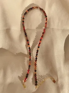 Macro view of bohemian faceted natural stone beaded necklace with gold lobster clasp