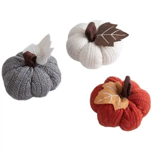 Set of three decorative knitted pumpkins in orange white and grey for autumn decor