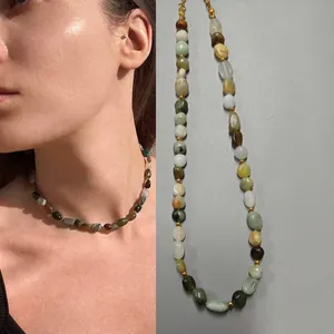 Close-up of irregular colorful natural stone necklace featuring vintage oil painting style
