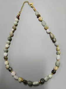 Close-up of retro luxury necklace with irregular colorful natural stones and gold beads