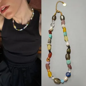 Close-up of irregular natural stone and pearl necklace worn by a model