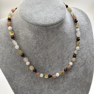 Detail shot of the irregular colorful natural stone necklace on a gray velvet bust