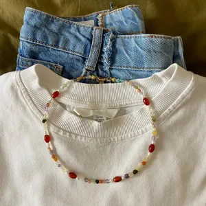 Close-up of a retro irregular colored natural stone necklace on a white t-shirt collar