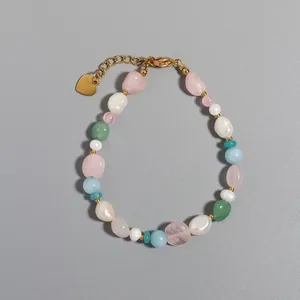 Close-up of vintage irregular natural stone beads and gold heart tag on bracelet
