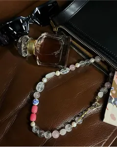 Detailed view of irregular colorful natural stone necklace with vintage pearl accents