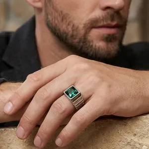 Gros plan d'une bague en titane pour homme avec pierre verte à la main