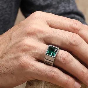 Gros plan détaillé d'une bague pour homme avec pierre émeraude et anneau d'acier