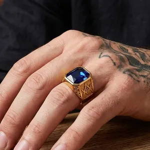 Primo piano di un anello massonico d'oro con una grande pietra blu sulla mano.