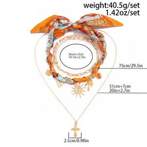 Detail des mehrlagigen Boho-Halsketten-Sets mit Seidenschal und Kreuzanhänger-Charm.