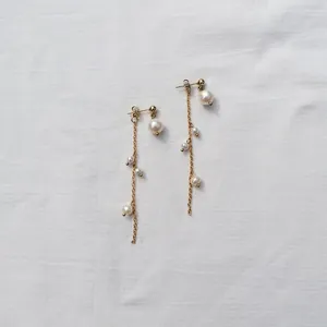 Detail view of elegant gold drop earrings featuring multiple freshwater pearls.