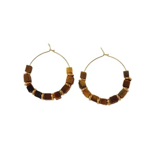 Close-up view of vintage hoop earrings featuring square brown stones and golden spacers