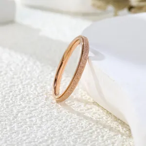 Macro view of a rose gold minimalist band ring featuring a fine sandblasted frosted texture