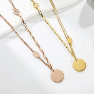 Close-up of vintage layered rose gold and gold necklaces with OT buckle round coin pendants.