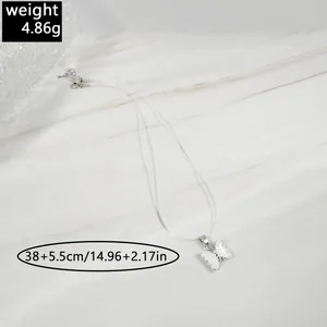 Détail du collier invisible élastique avec pendentif papillon et indications de taille