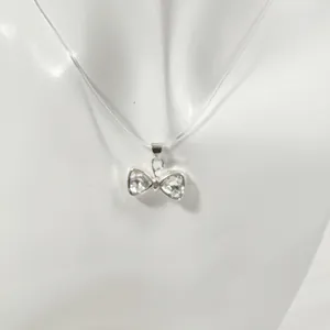 Collier invisible délicat avec un pendentif nœud en cristal étincelant pour un look épuré.