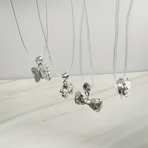 Gros plan de quatre colliers invisibles larmes de sirène avec divers pendentifs
