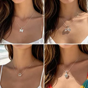 Colliers argentés minimalistes avec pendentifs papillon et étoile sur la plage