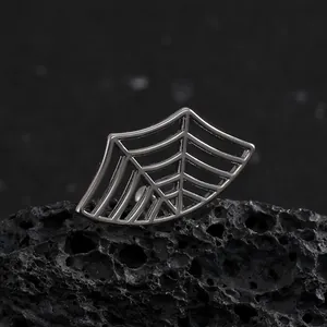 Orecchino gotico a ragnatela in argento su sfondo di roccia vulcanica nera porosa