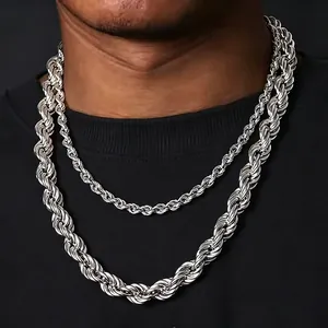 Detalle de collares de cadena de cuerda de acero inoxidable sobre una camiseta negra.