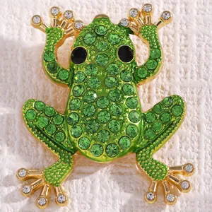Detaillierte Nahaufnahme eines Frosch-Ohrrings aus Legierung mit grünen Strasssteinen.