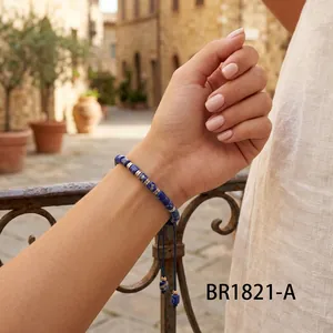 Detailed shot of handmade lapis lazuli barrel bead braided bracelet on a woman's wrist